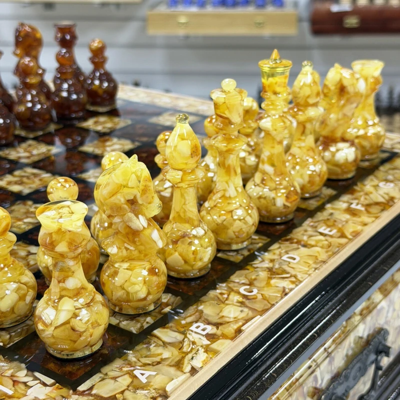 Шахматы из янтаря и бука в ларце с выдвижными ящиками 47 см