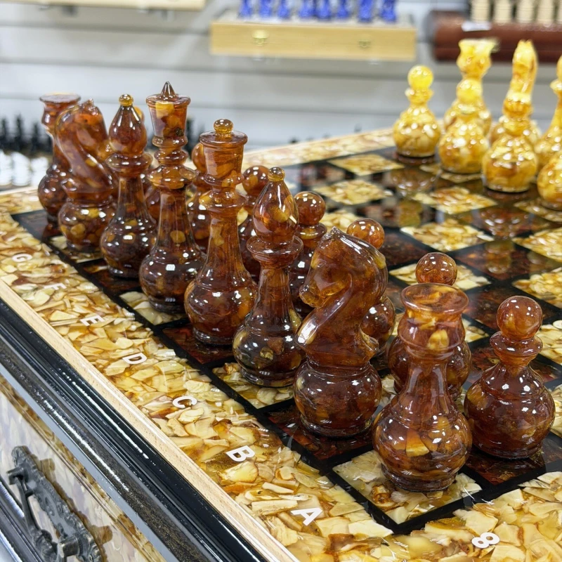 Шахматы из янтаря и бука в ларце с выдвижными ящиками 47 см